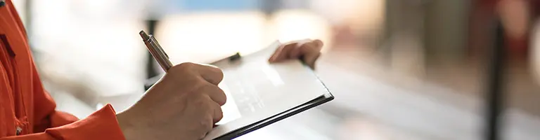 Person signing clipboard